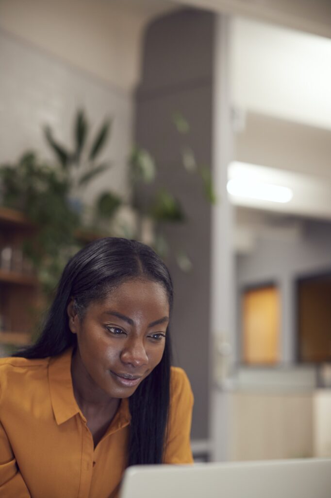 Close Up Of Businesswoman Working On Laptop In Modern Office